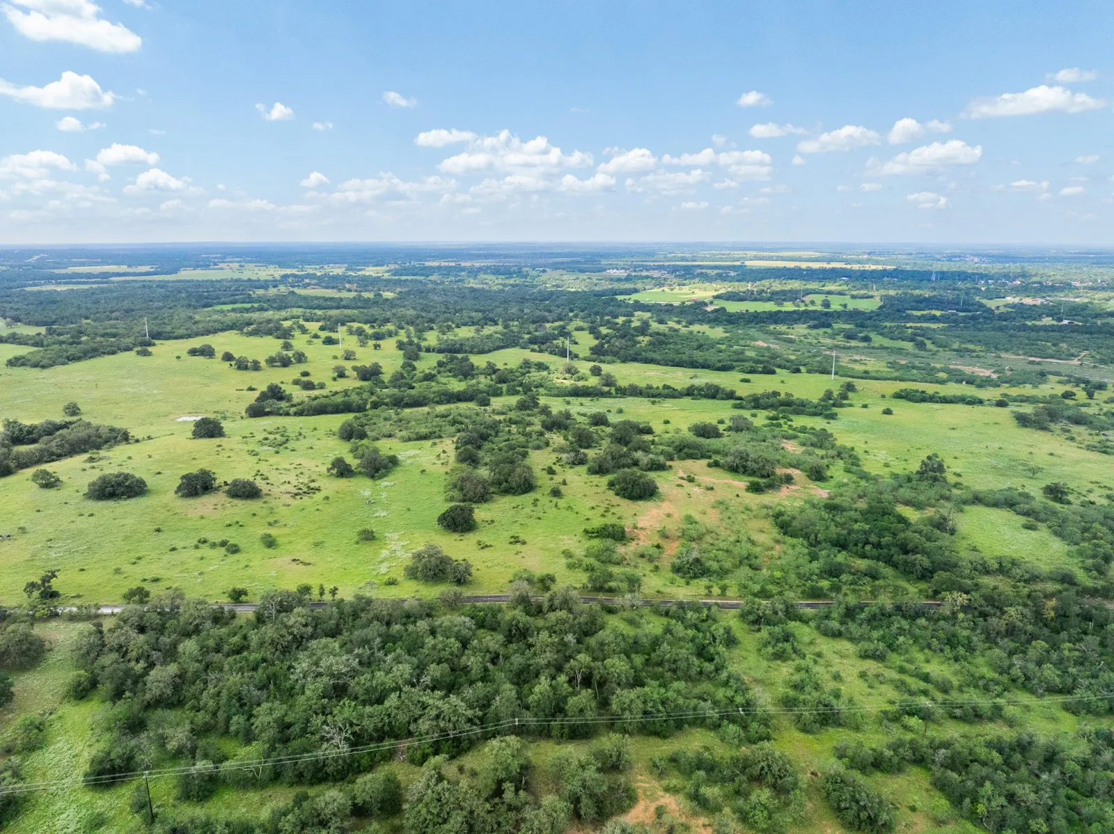 Aerial view of green Central Texas ranch land — La Tierra Realty